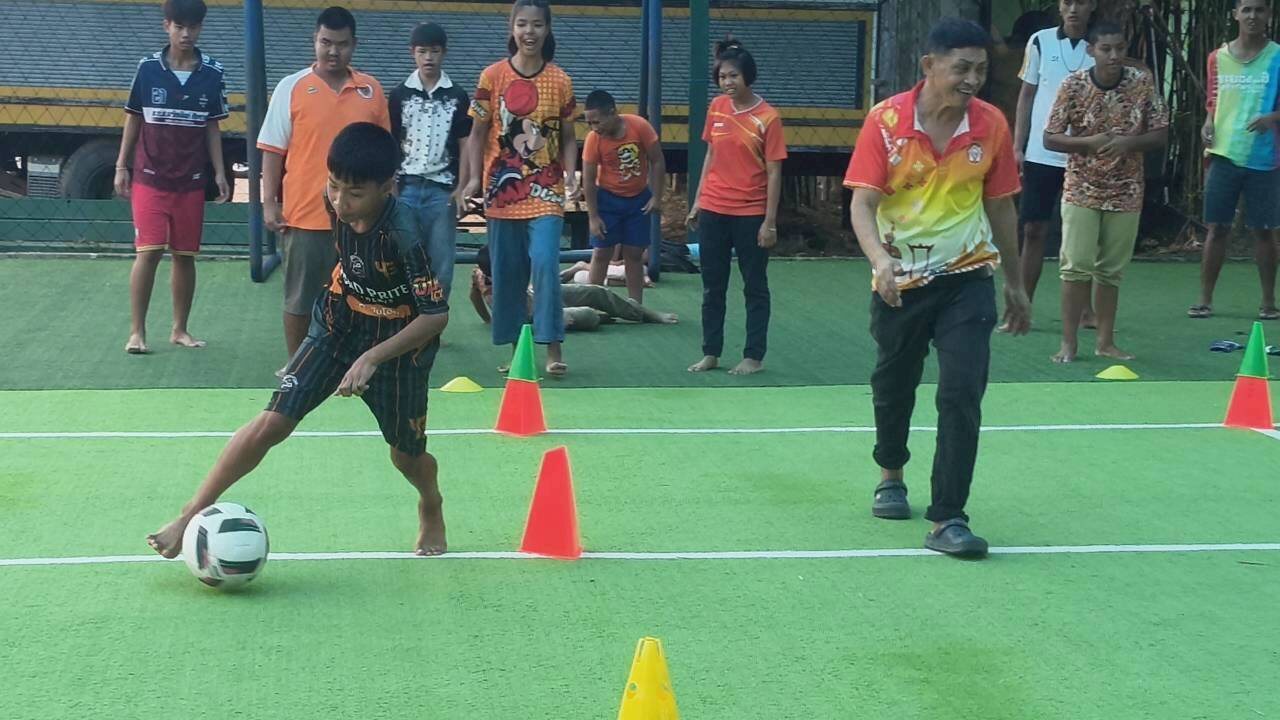 A young player dribbling through cones during an APJT session